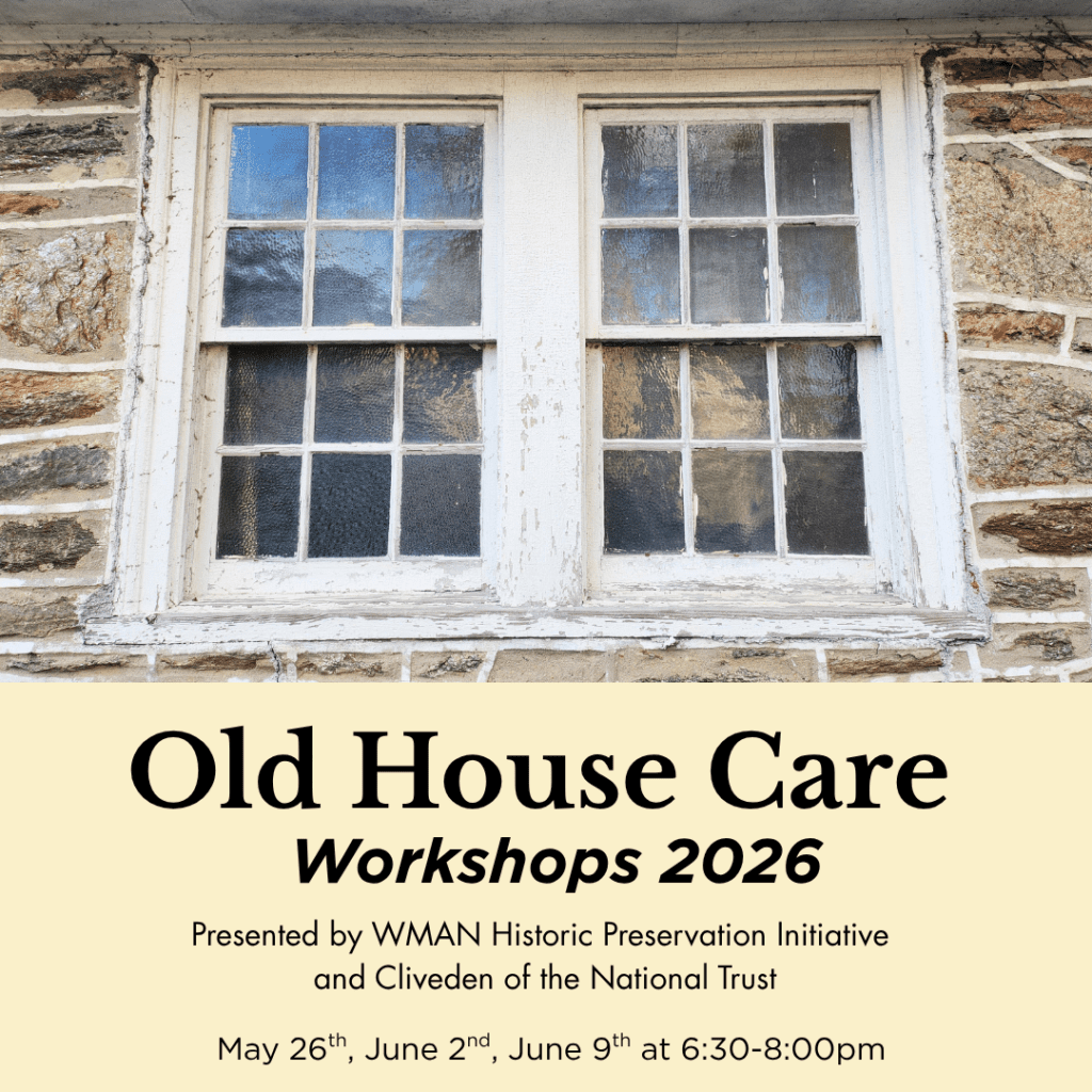 Two historic double hung six-over-six divided light windows in a natural stone wall.